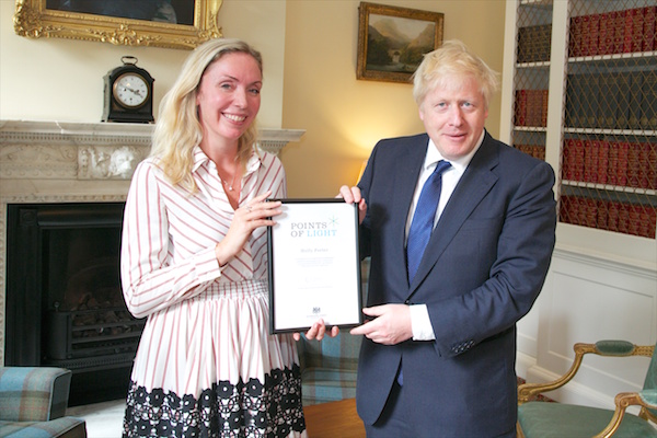 Holly Porter receiving her Points of Light award from Prime Minister Boris Johnson