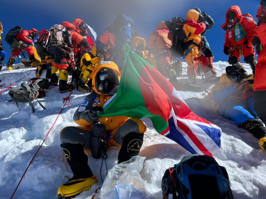 Akke with a Bangladeshi and Union Jack flag at the peak of Everest
