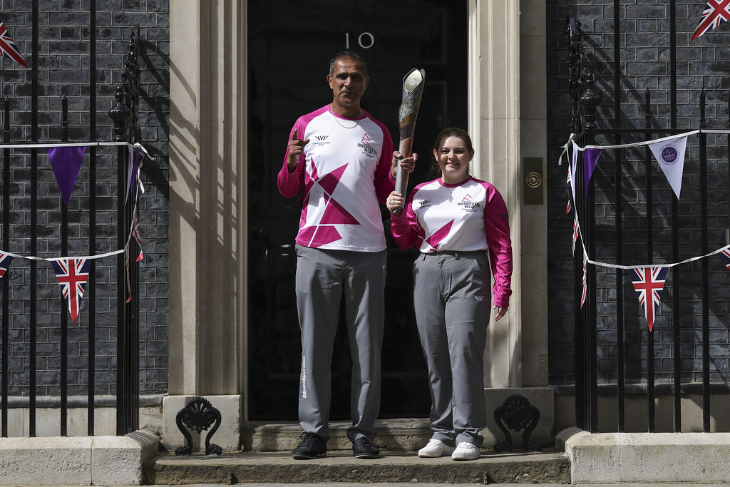 Kash with fellow Point of Light Courtney Hughes outside Downing Street carrying the Commonwealth Games Queen's Baton